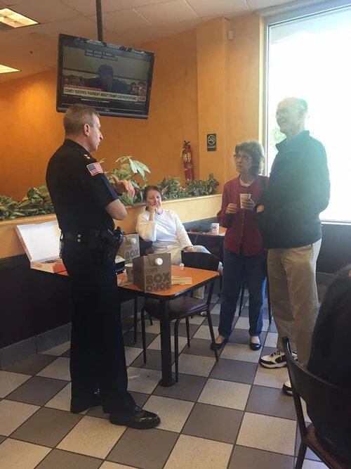police officer speaking with coffee shop patrons
