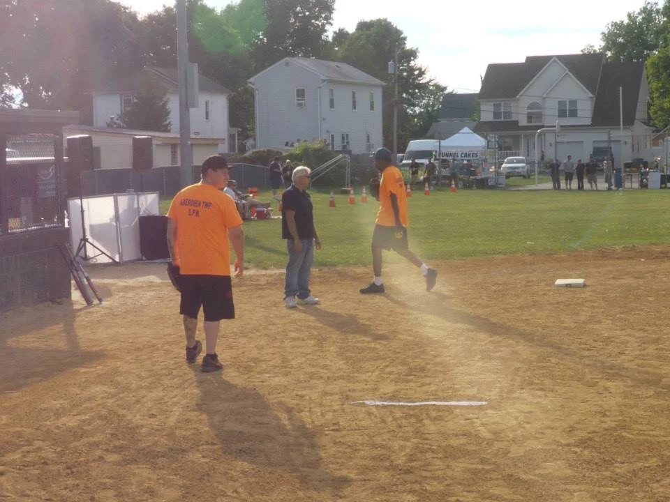 3 people standing on a baseball field