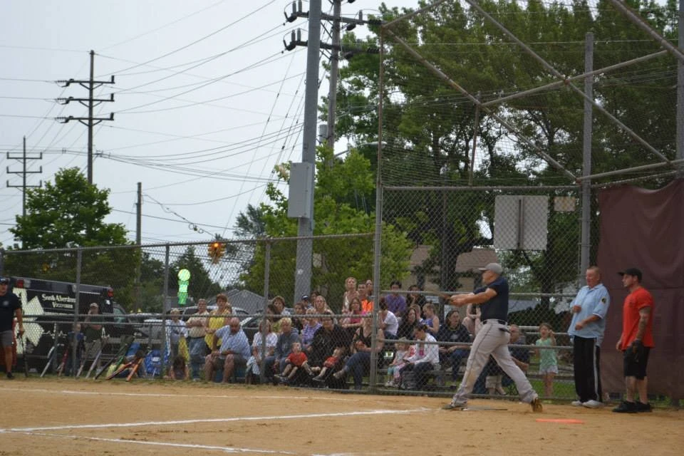 a baseball player swings his bat at an incoming basecall