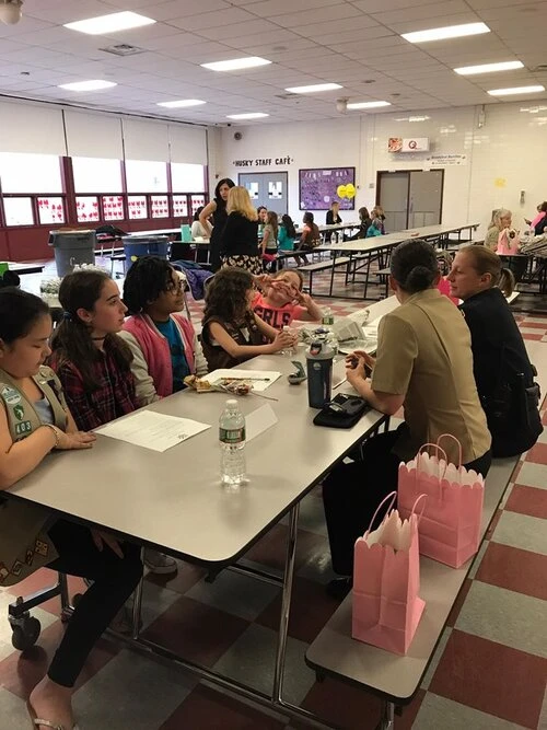 children sit with two police offices at a lunch room table