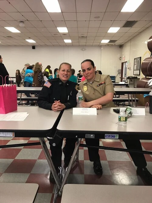 two police officers sit at a lunch room table