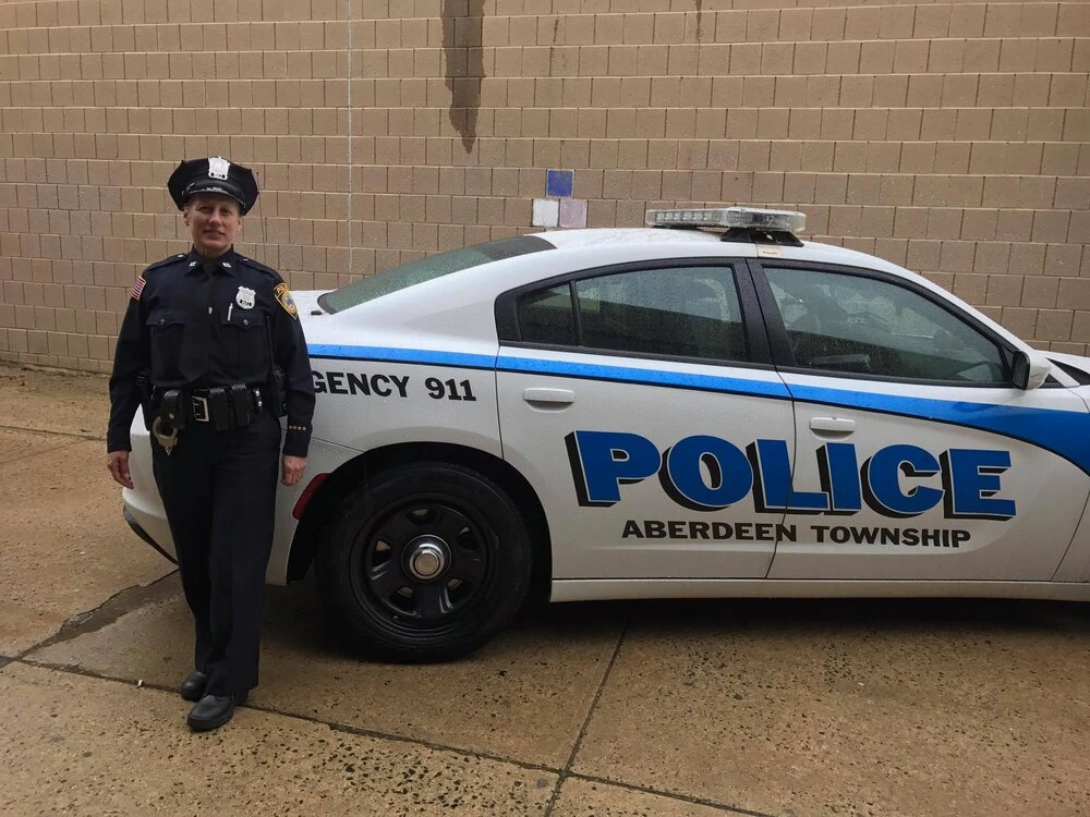 a police officer stands in front of a police car