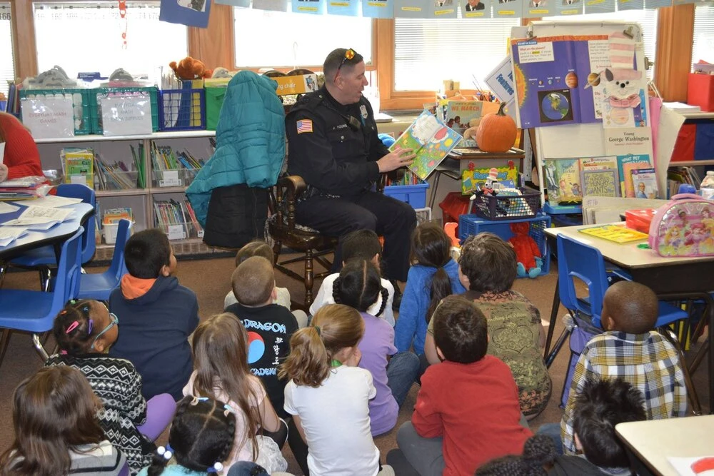 a police officer reads to children