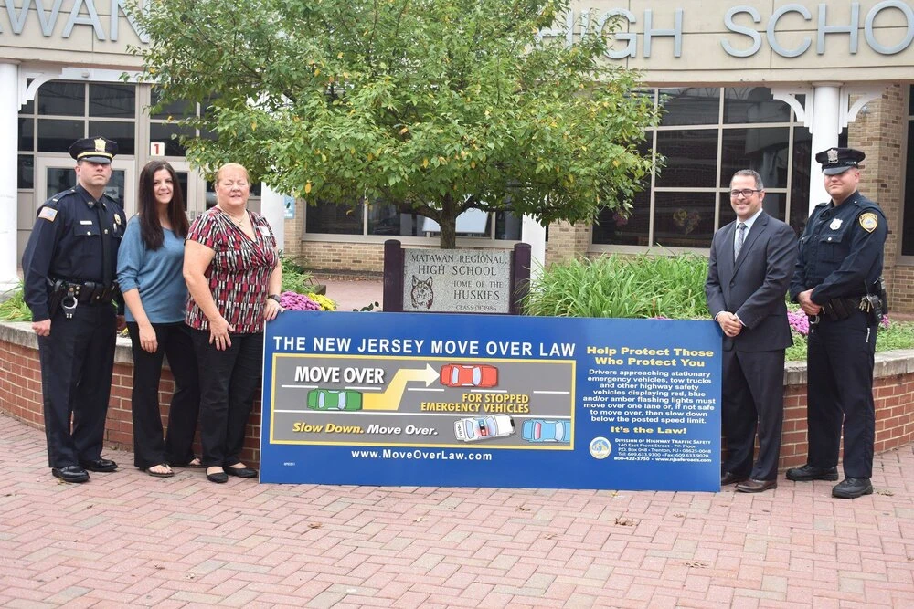 5 people stand on the sides of a sign that reads "move over awareness campaign"
