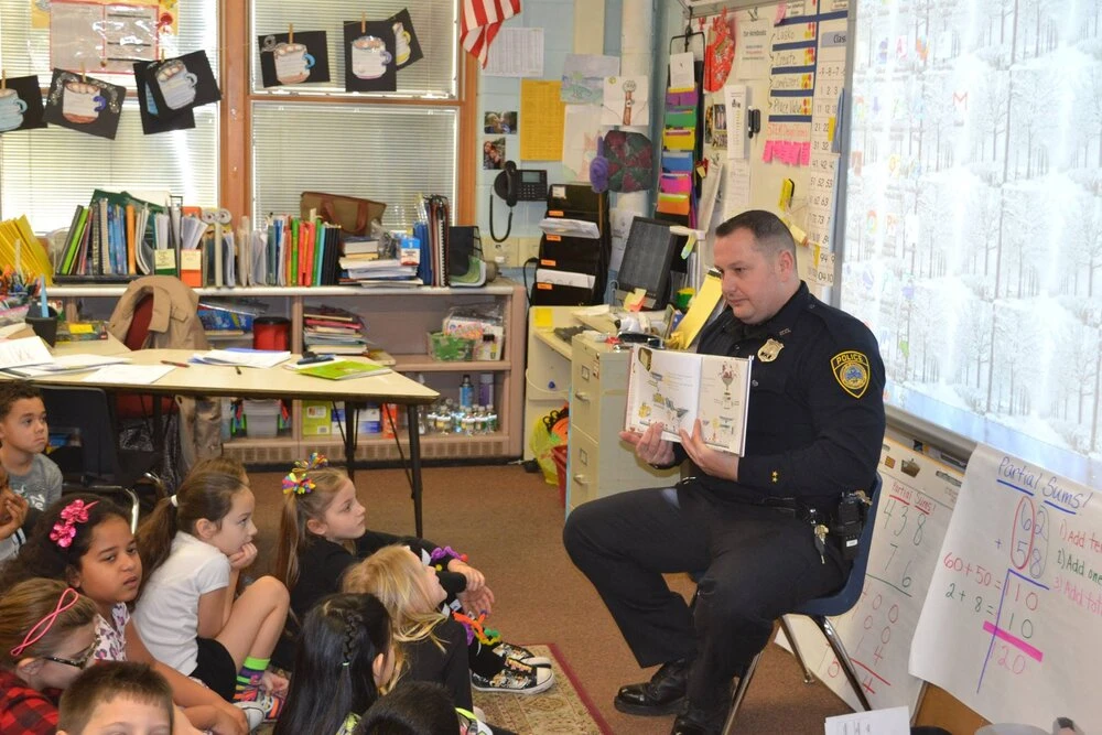 a police officer reads to children