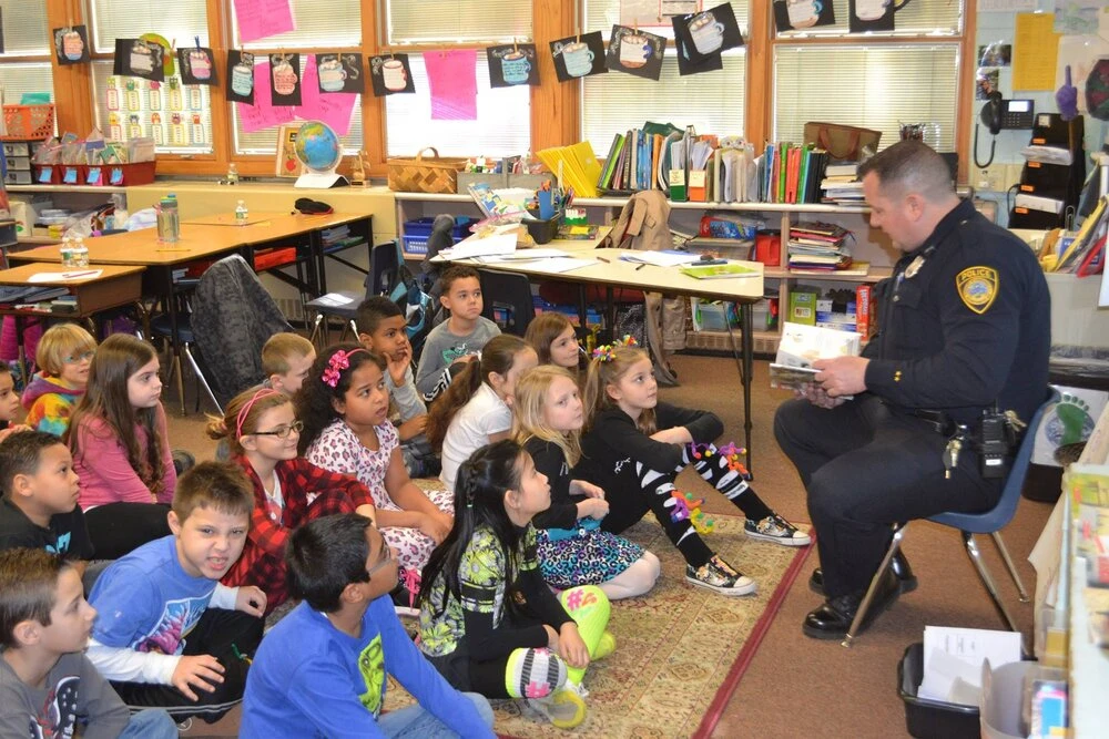 a police officer reads to children