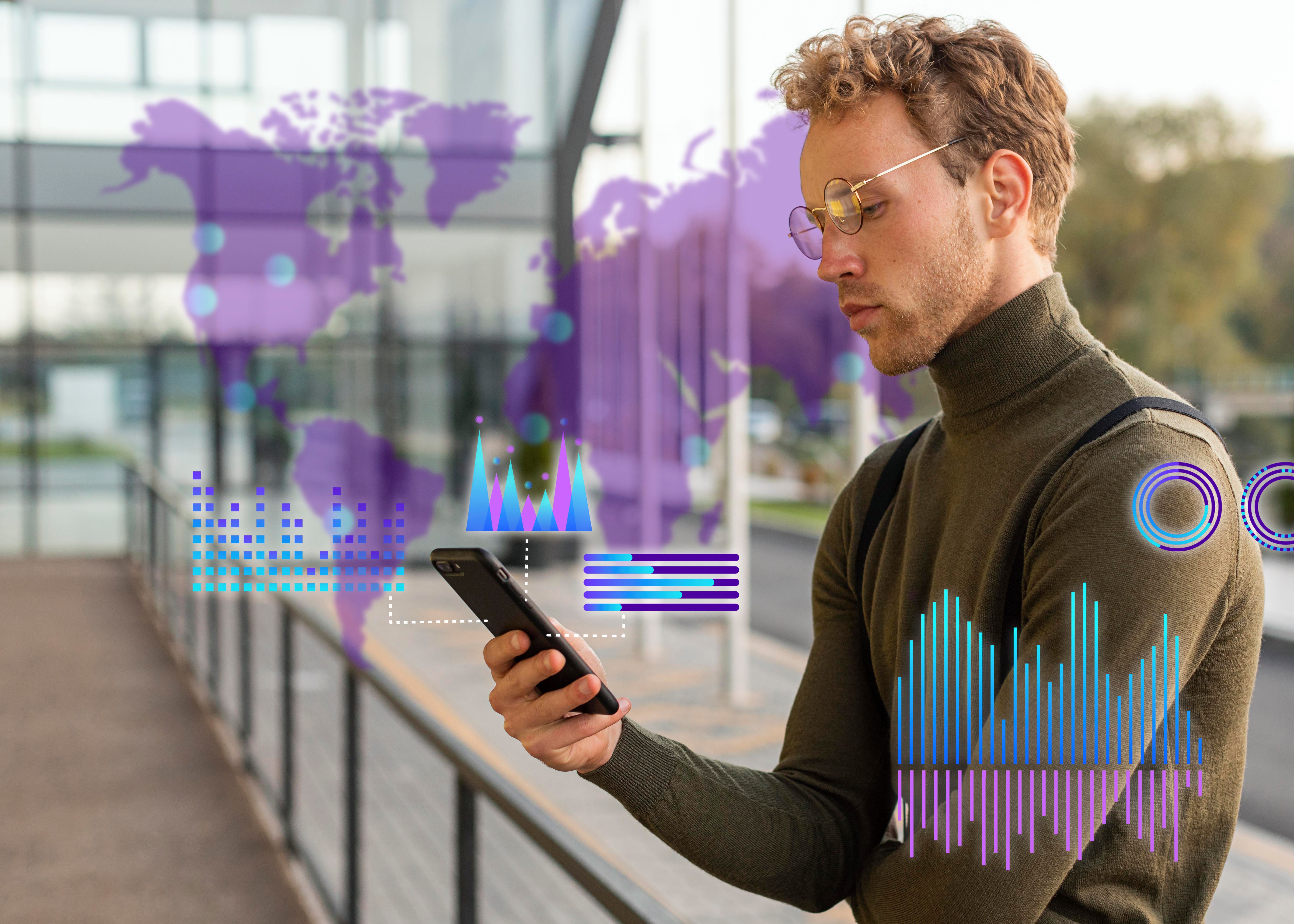 Young man with glasses looking at smartphone with overlaid digital charts and a purple world map in the background.