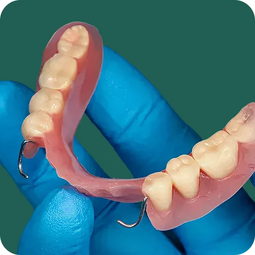 Single tooth denture held up to show its natural-looking replacement tooth