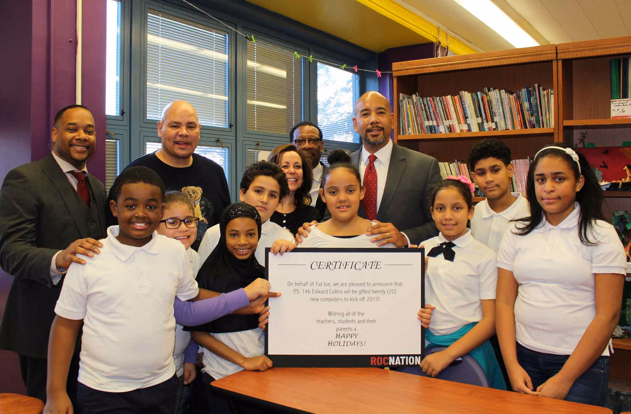 Students and staff celebrate Roc Nation computer donation certificate at PS 146