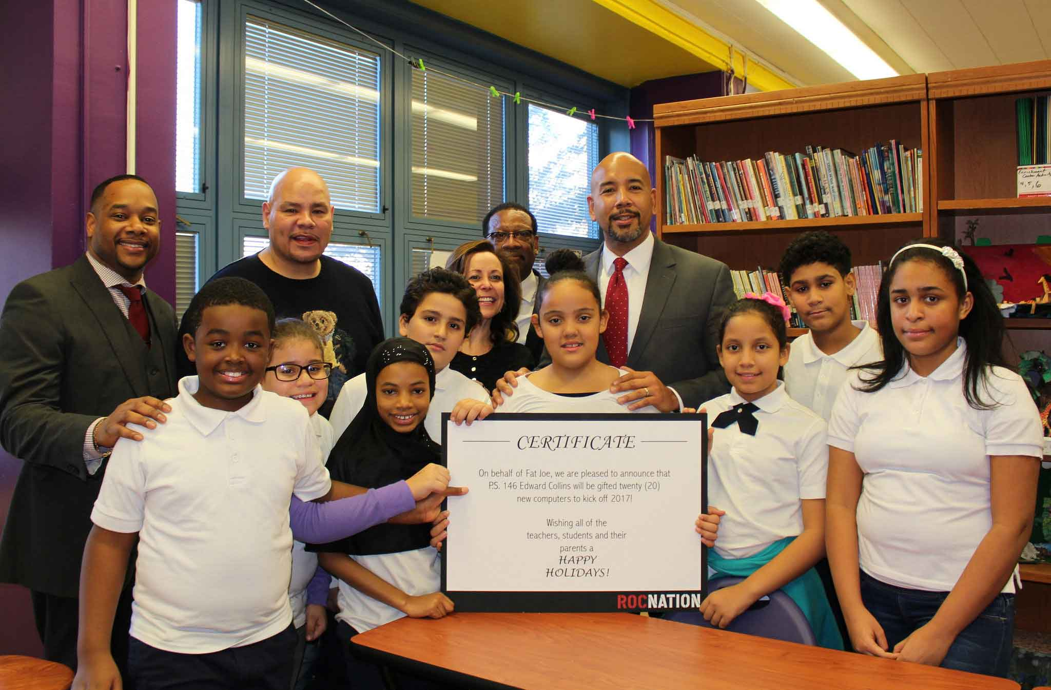 Students and staff celebrate Roc Nation computer donation certificate at PS 146
