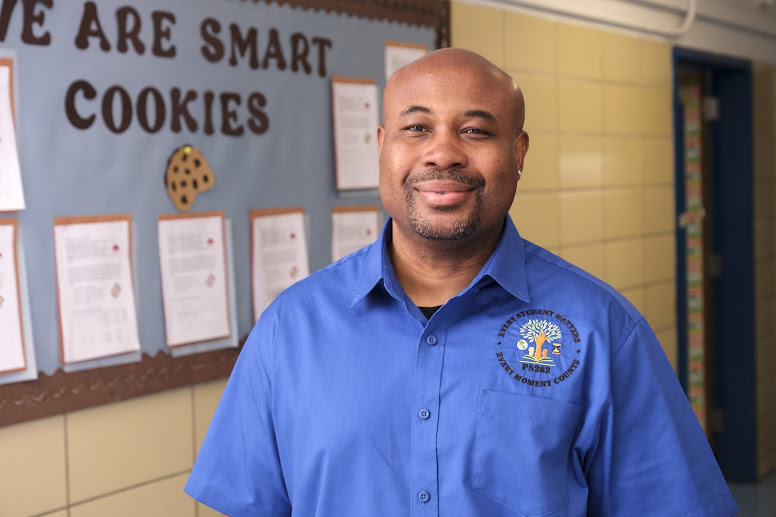 PS 262 staff member Mr. George smiling in school hallway
