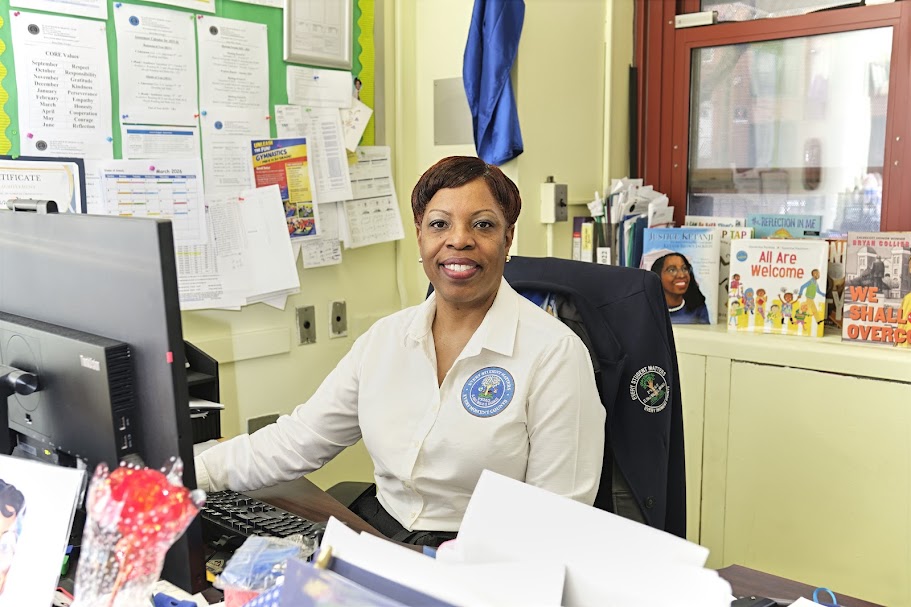 Ms. Barter smiling at her desk in a school office