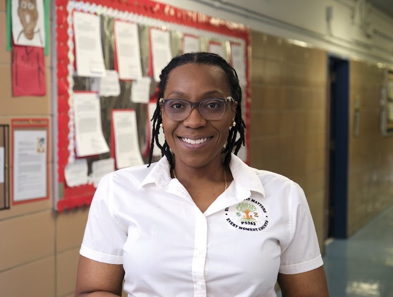 PS262 staff member Ms. Bobb smiling in school hallway