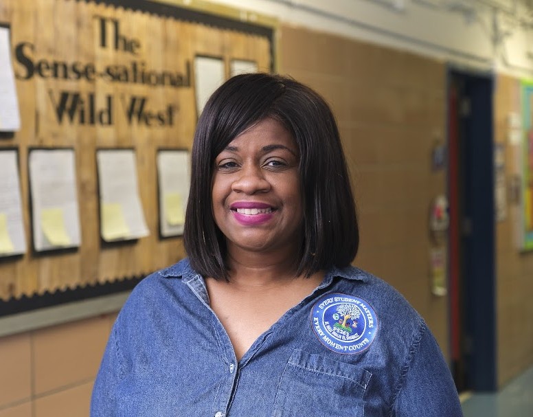 Ms. Tyson smiling in a school hallway at PS 262