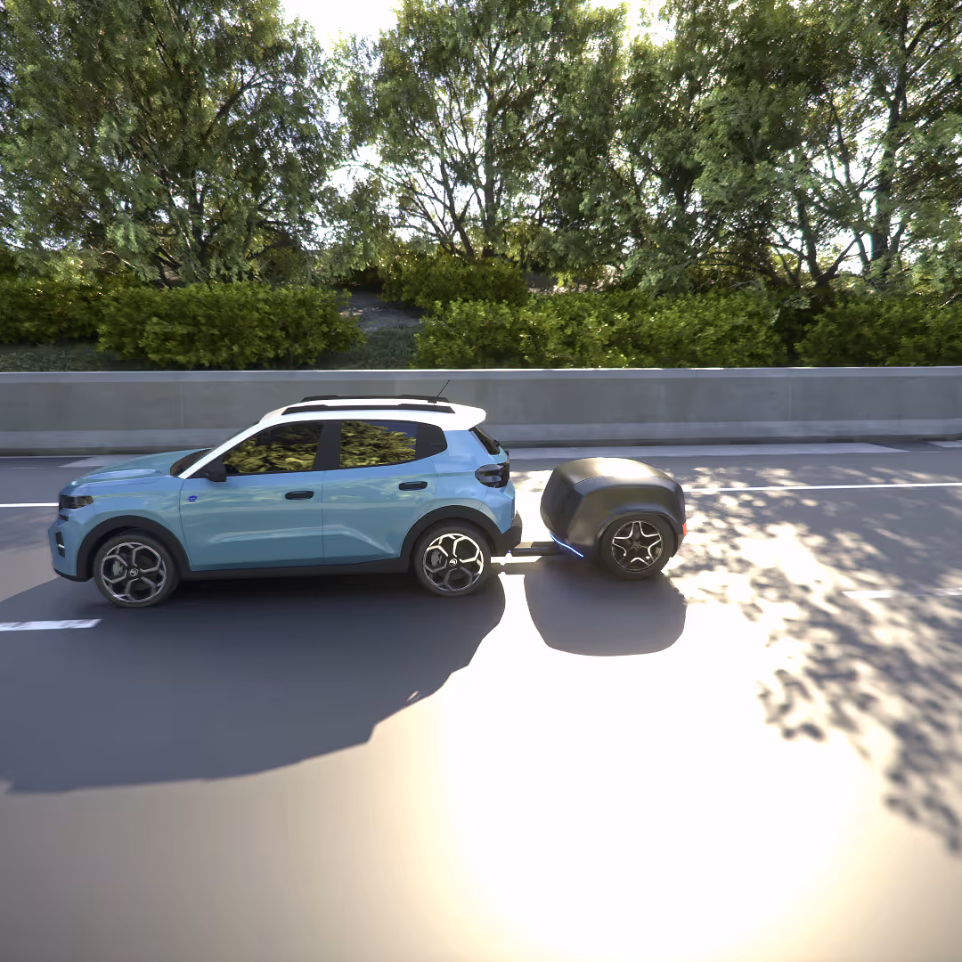 Voiture bleue avec toit blanc tirant une petite remorque noire sur une route bordée d'arbres verts.