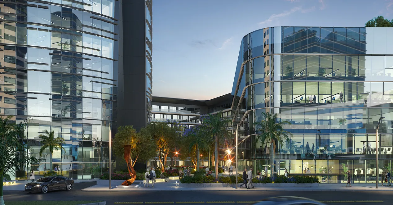 A large glass building with palm trees in front of it.