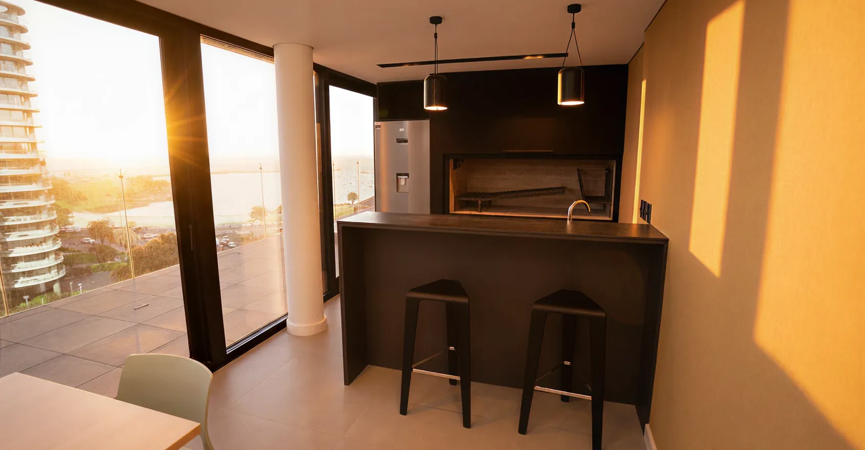 A kitchen with two stools next to a bar.