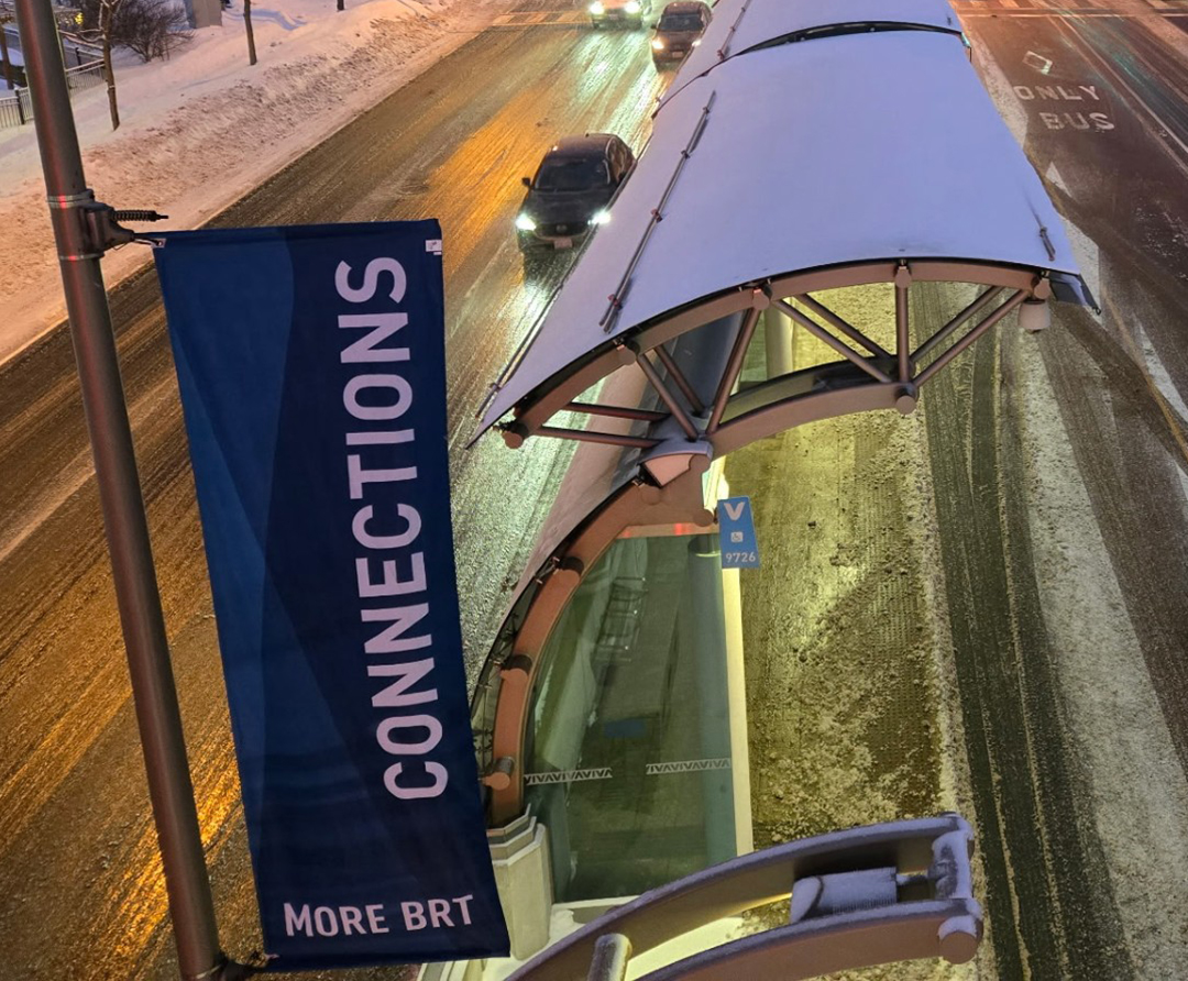 Large white letters spelling 'BLUE' in front of a lake with paddle boats, green hills, and lodge-style buildings under a blue sky.