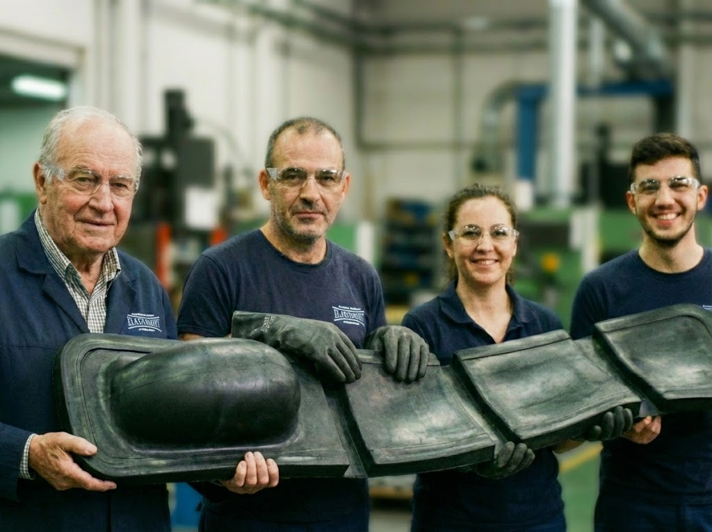 L'équipe Elastomont présente une grande pièce en caoutchouc moulée spéciale, illustrant leur innovation et vision industrielle.