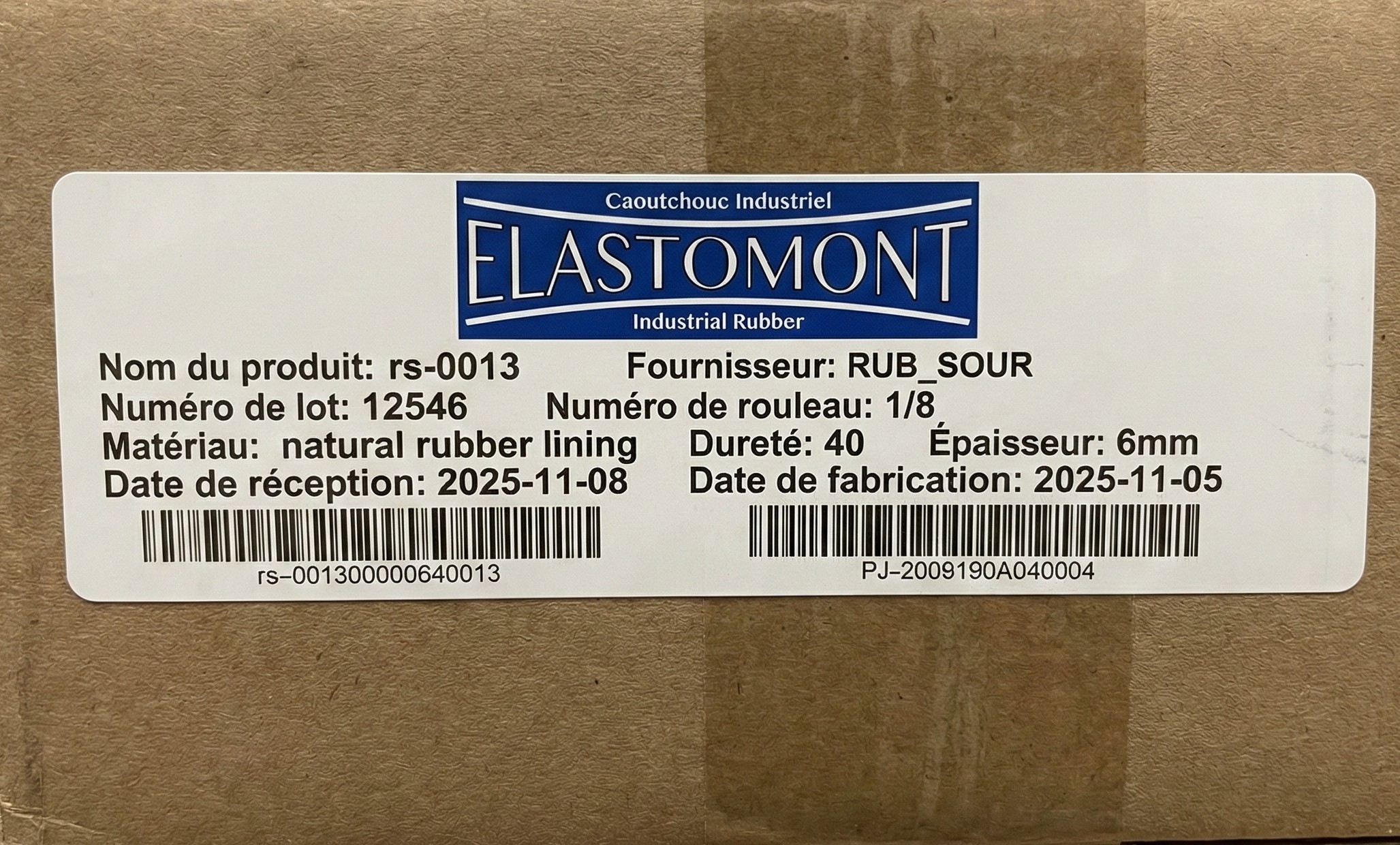 Étiquette de suivi de lot et contrôle qualité (QC) ERP Elastomont collée sur une boîte en carton.