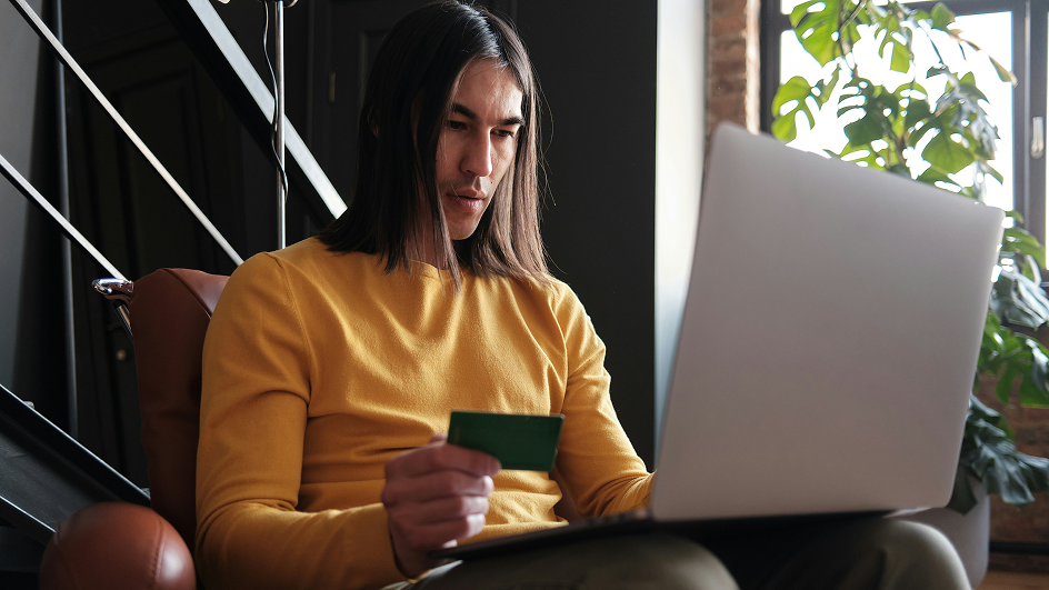 A person sitting at a table holding their credit card.