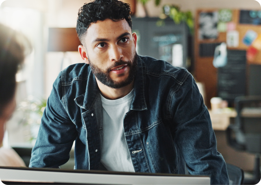 An image of a man working on a laptop in a coffee shop