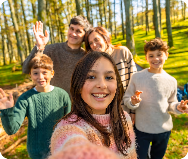 Familia compuesta de tres niños y padres, en pose de selfie en un jardín