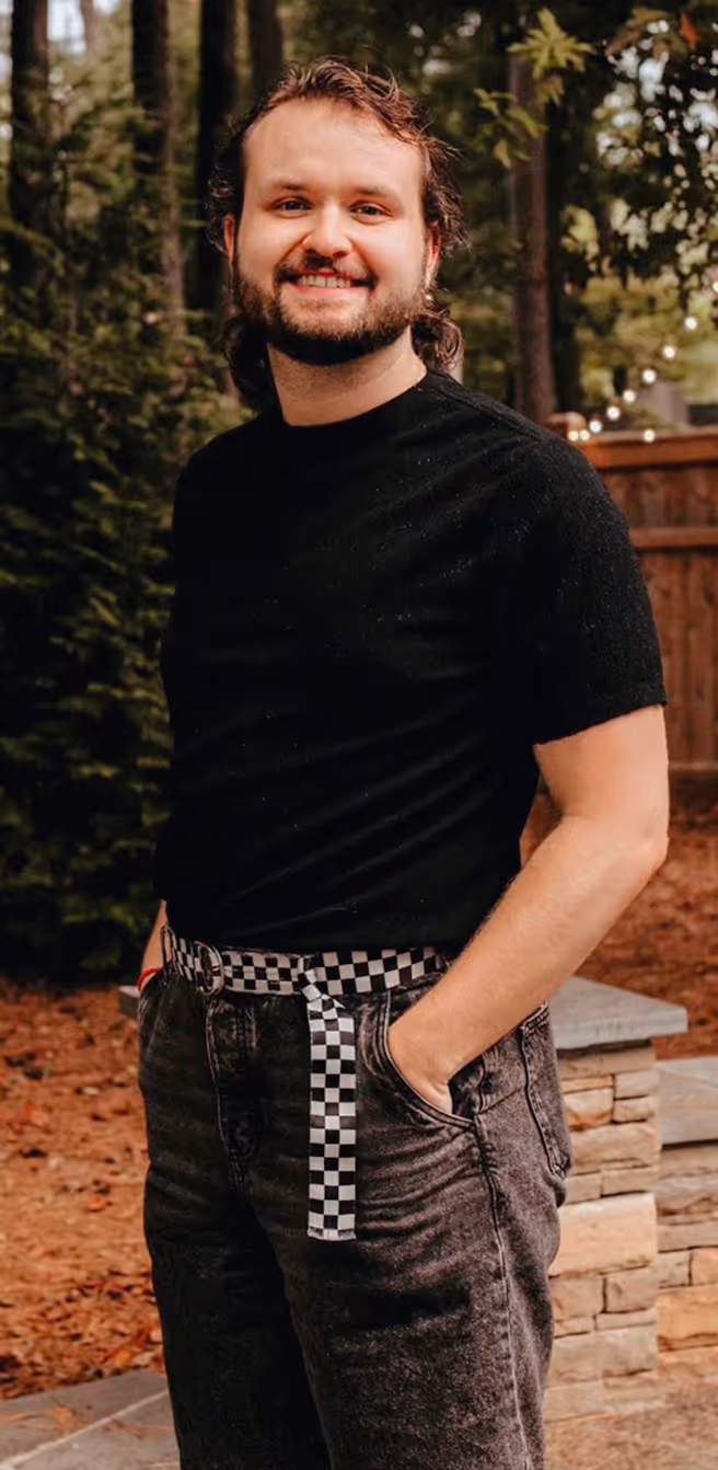 Jay standing in a backyard smiling