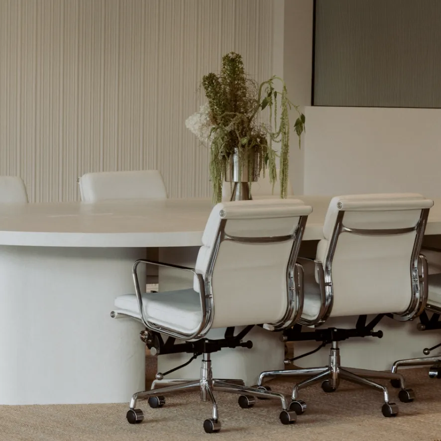 Meeting room at the Pearl Interiors studio in Noosa Heads, with a curved plaster table and fluted timber wall panelling