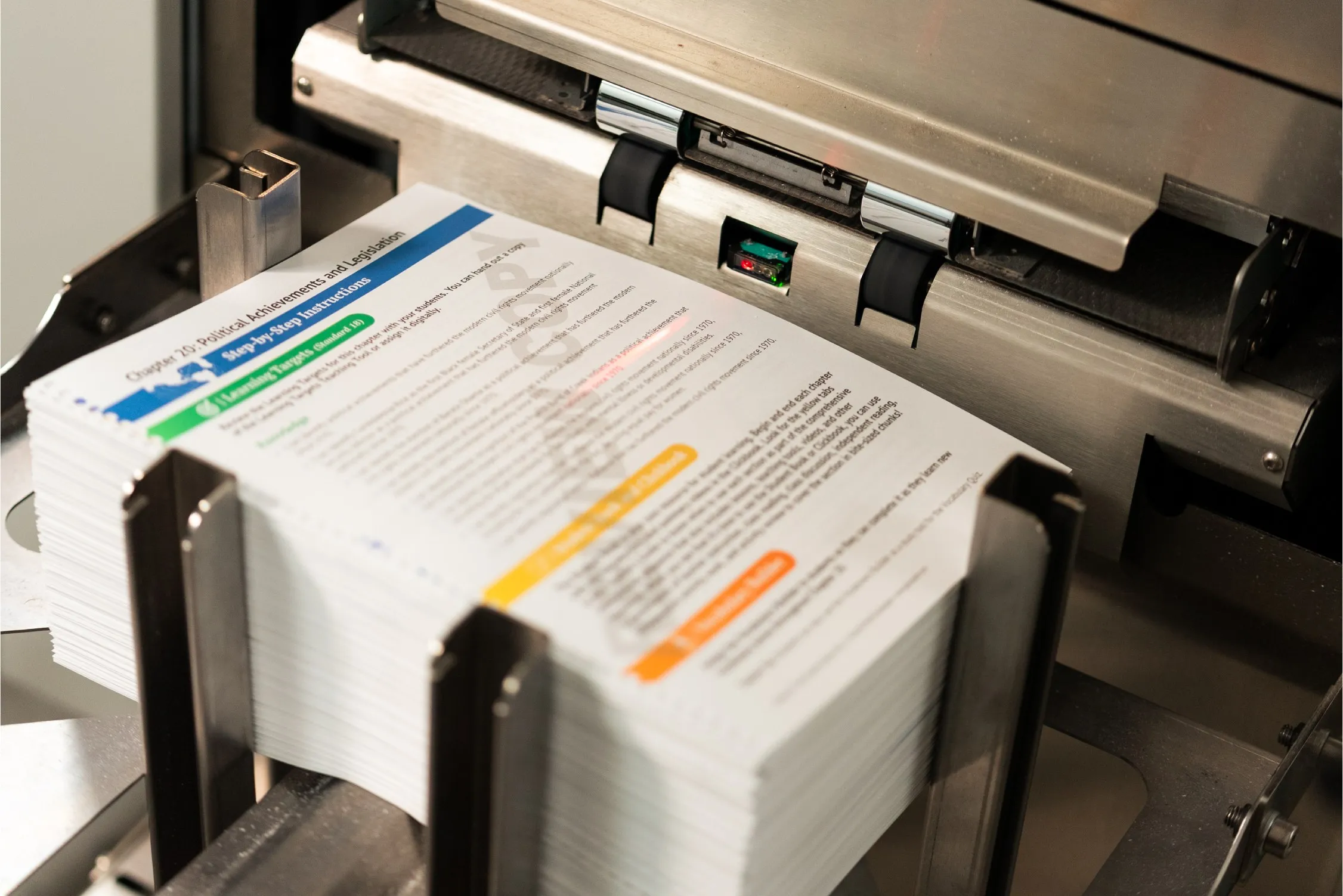 Stack of printed civics curriculum pages on production line