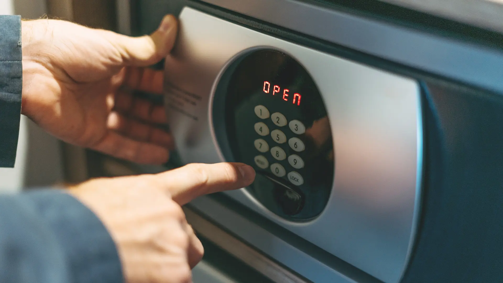 A man keying in the code to the wall-mounted safe in his home. Our locksmiths install safes in all Hobart homes.
