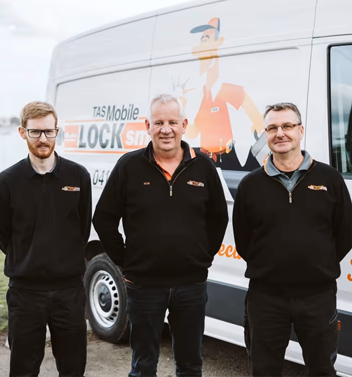 Three mobile locksmith team members standing in front of service van