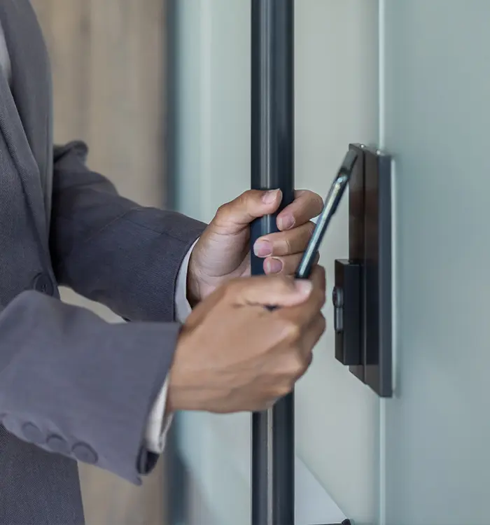 Person in suit using smartphone near window or glass door
