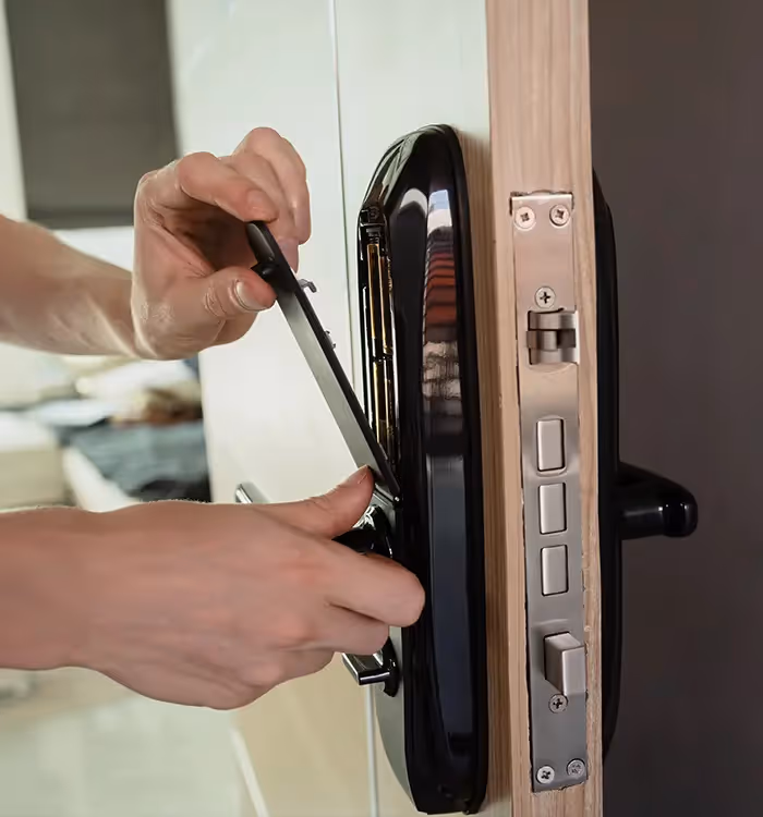 Hands installing or repairing a modern electronic digital door lock