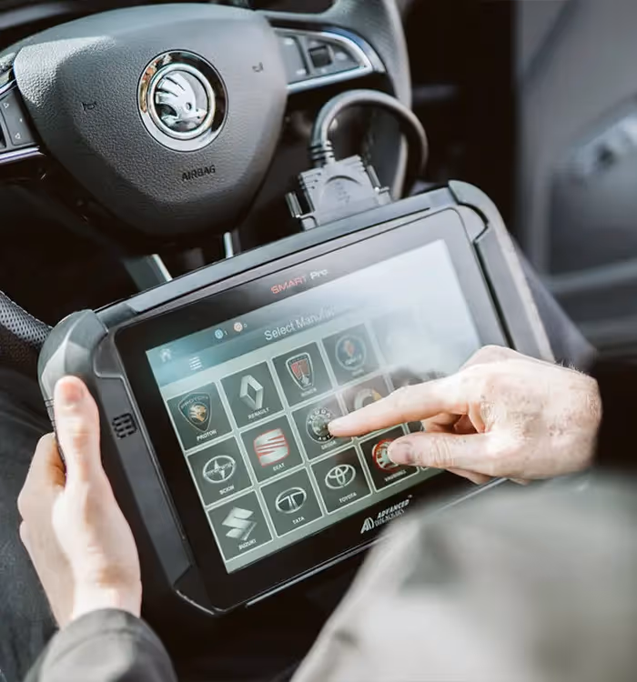 Diagnostic tablet showing car brand logos in vehicle dashboard