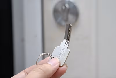 A close-up of a client’s hand holding a bent house key. This happens all the time, and our broken key extraction locksmiths help Hobart clients with issues like this all the time.