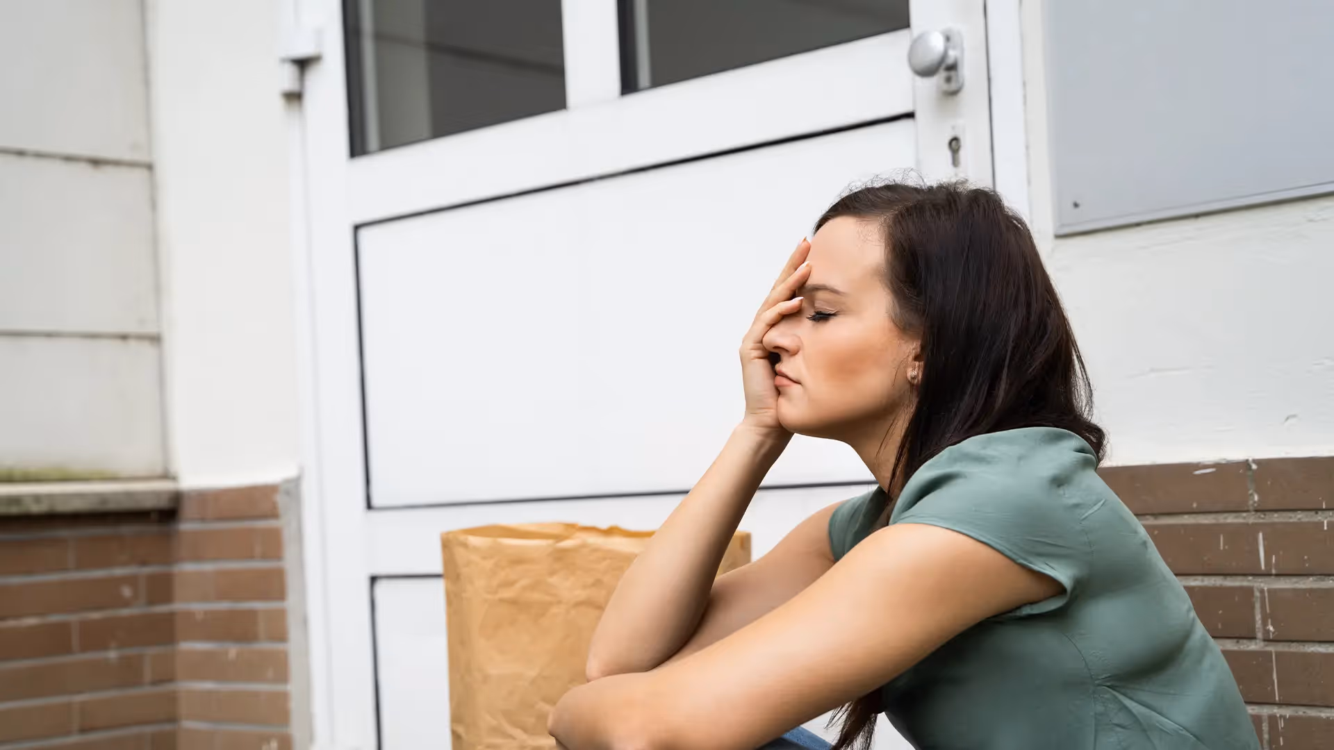 A frustrated woman sitting on her porch with her groceries. She’s accidentally locked herself of our her home. Our lockout locksmiths help Hobart locals get back in ASAP.