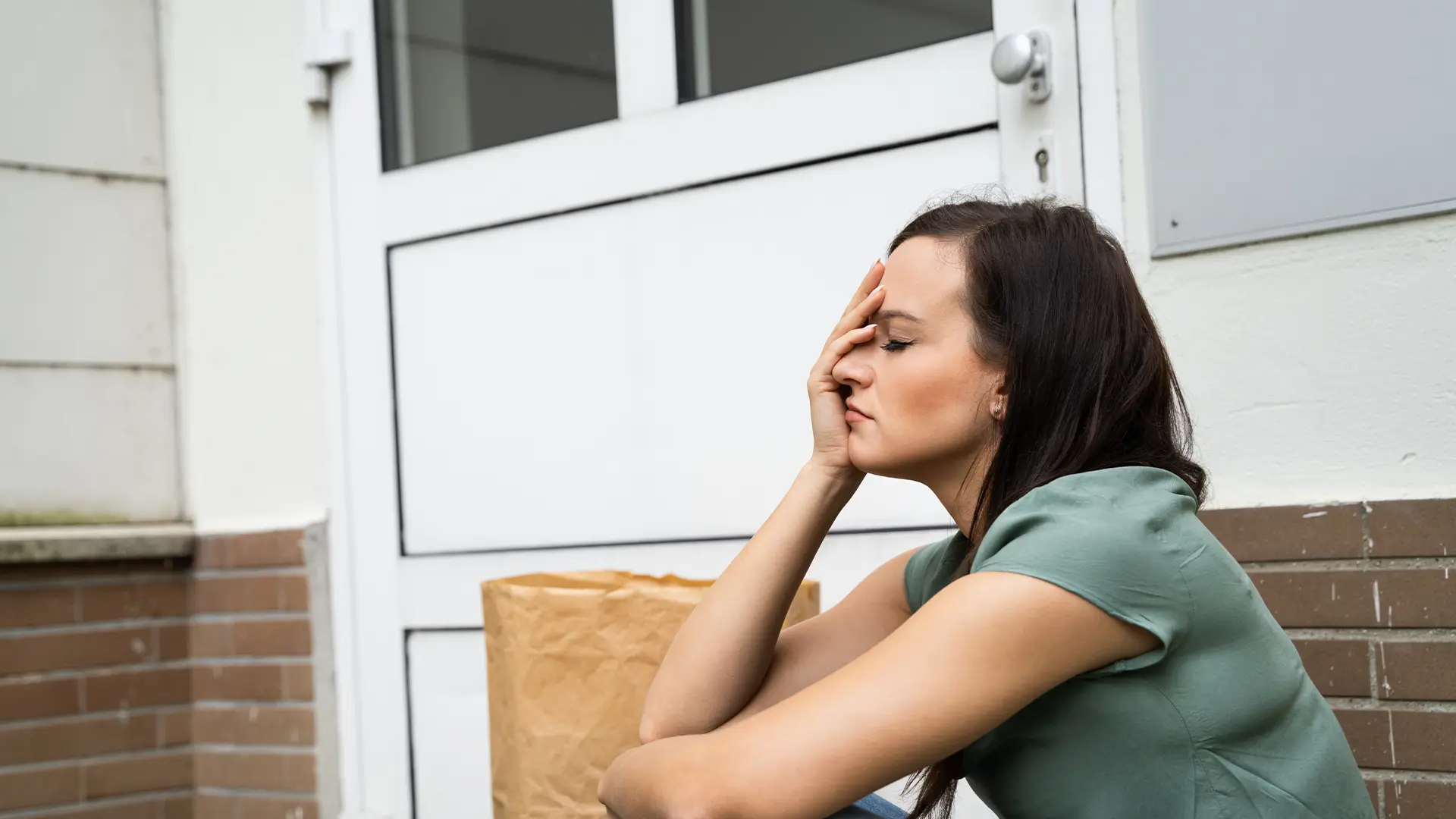A frustrated woman sitting on her porch with her groceries. She’s accidentally locked herself of our her home. Our lockout locksmiths help Hobart locals get back in ASAP.
