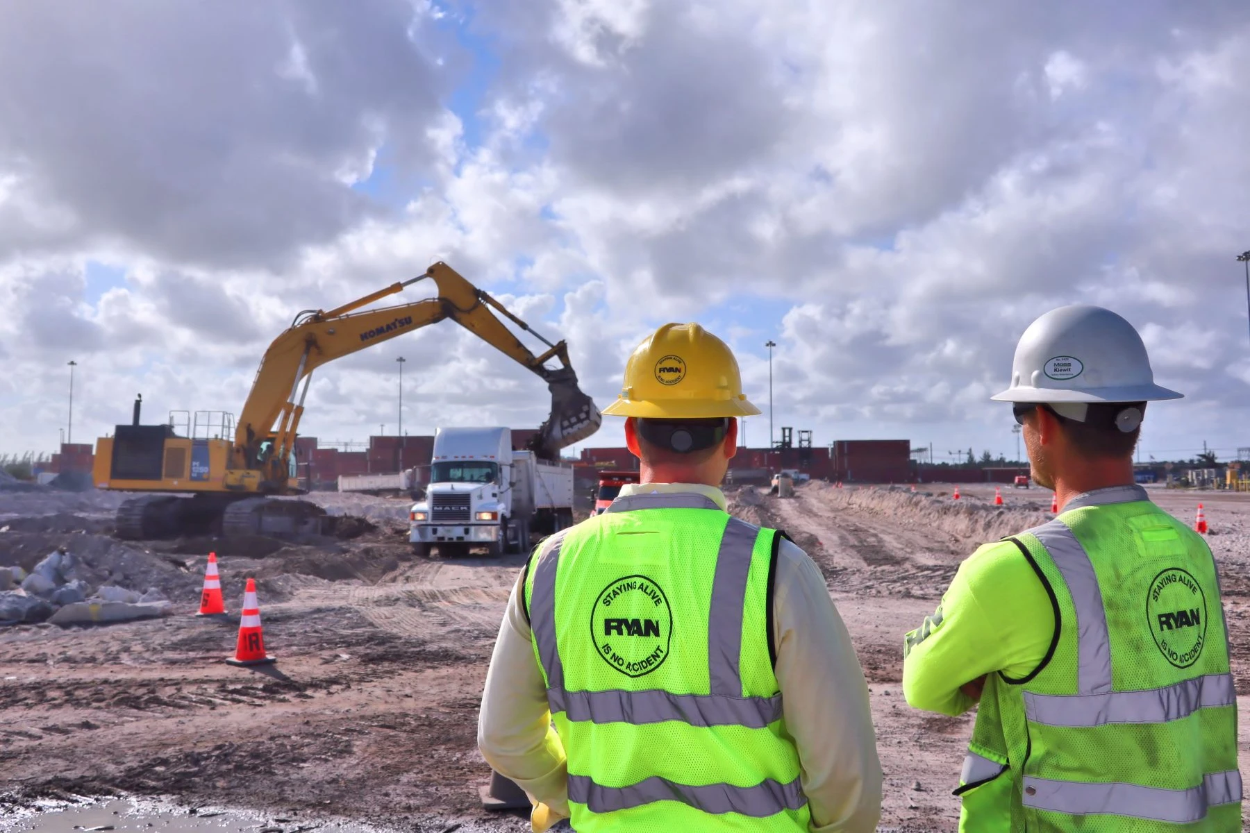 Ryan crew members watching an excavator load a dump truck on a jobsite