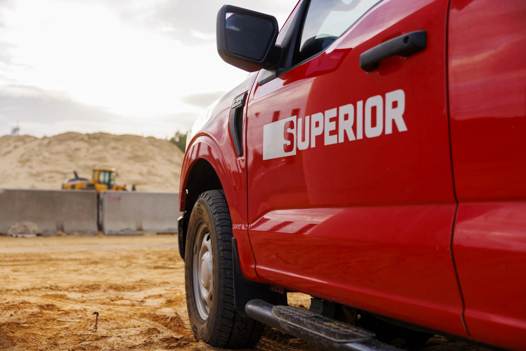 Superior Construction truck on a jobsite with a loader in the background