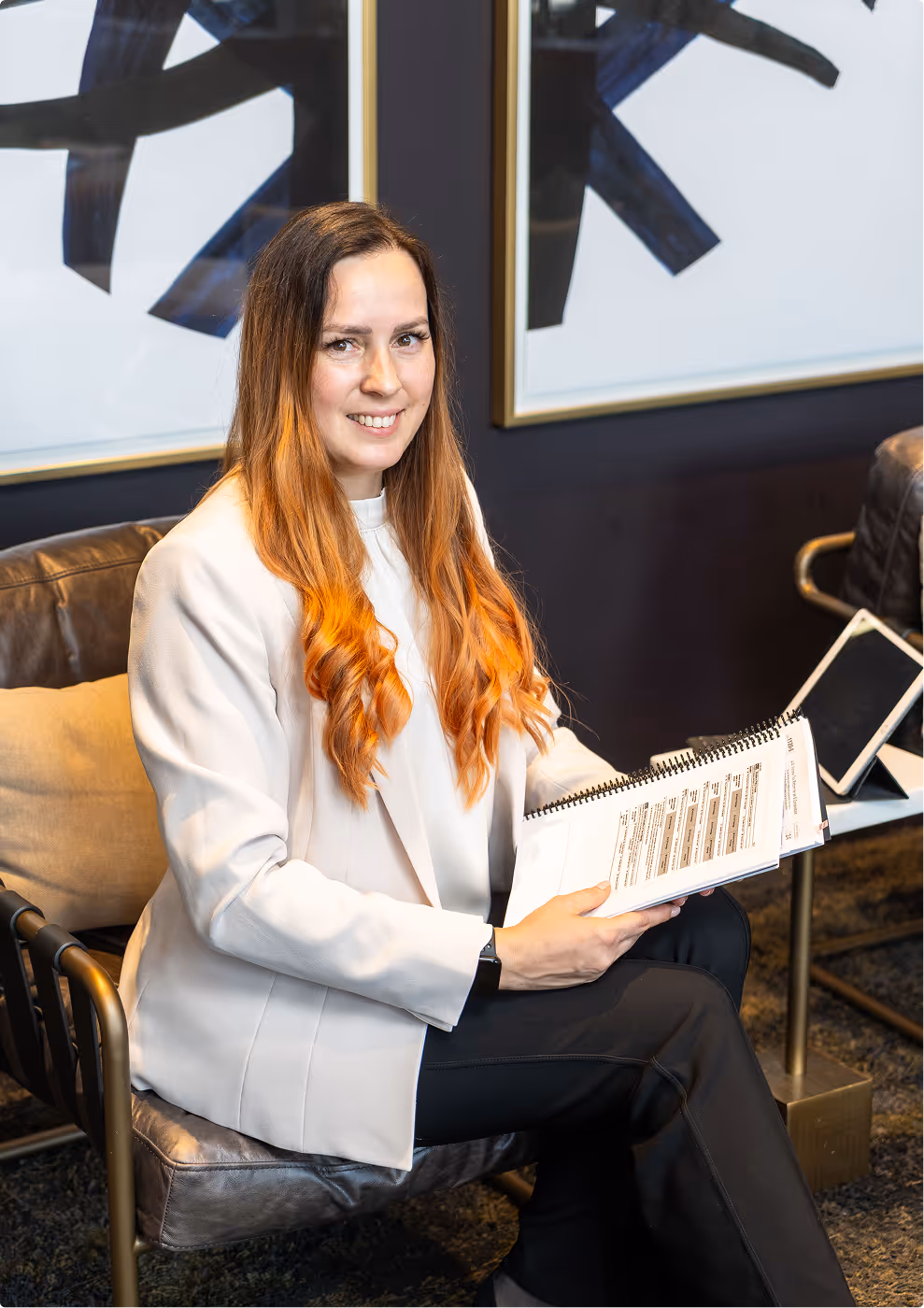 Smiling tax professional holding documents in an office.