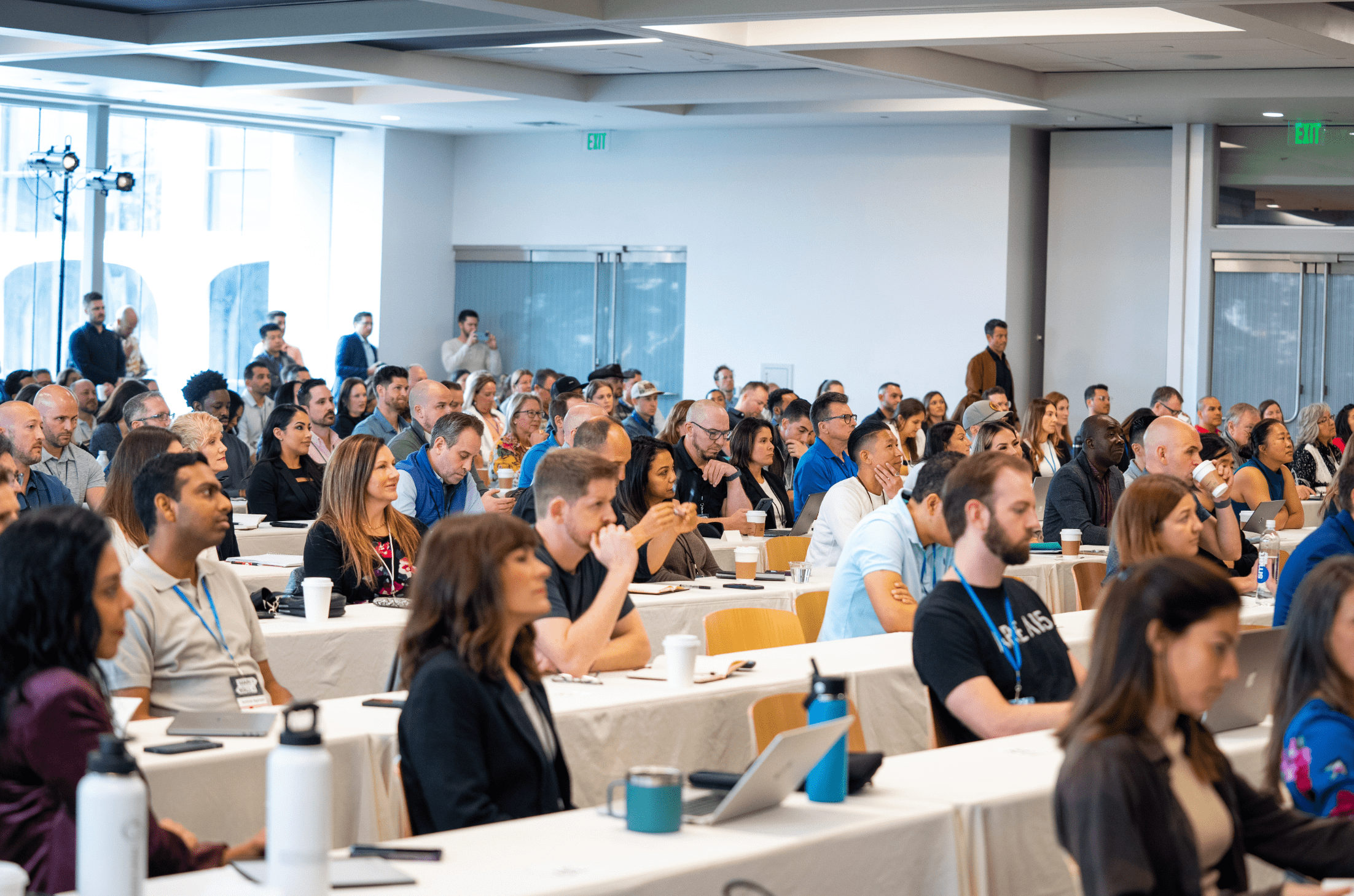 A large group of people attentively listening at a business conference.