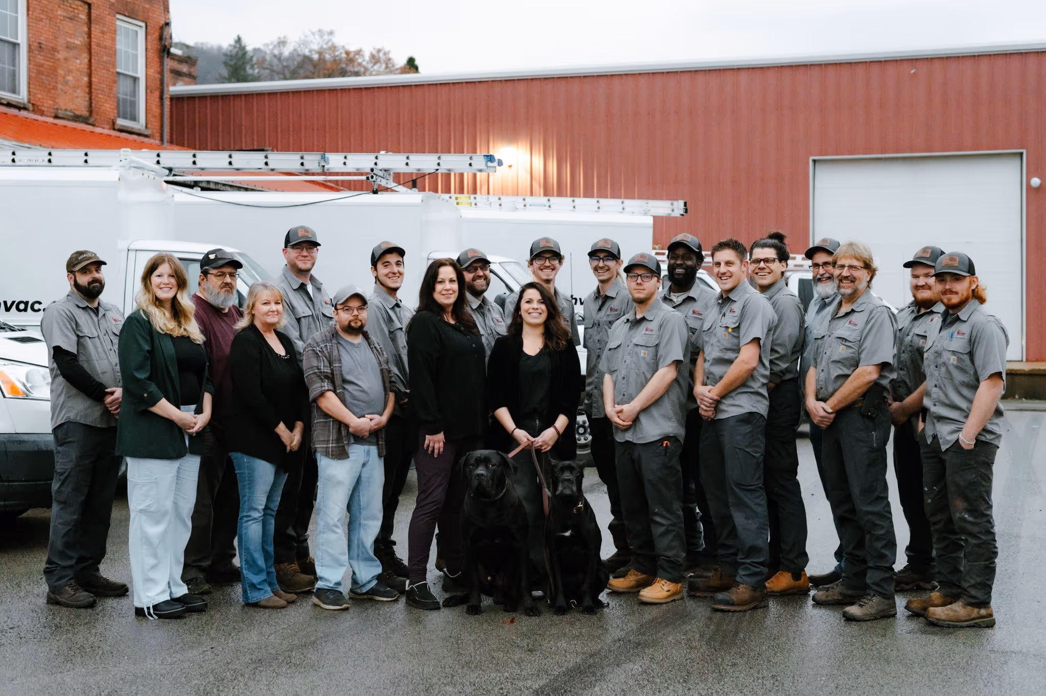 A team of professionals posing in front of company vehicles, showcasing the hardworking individuals behind the business.