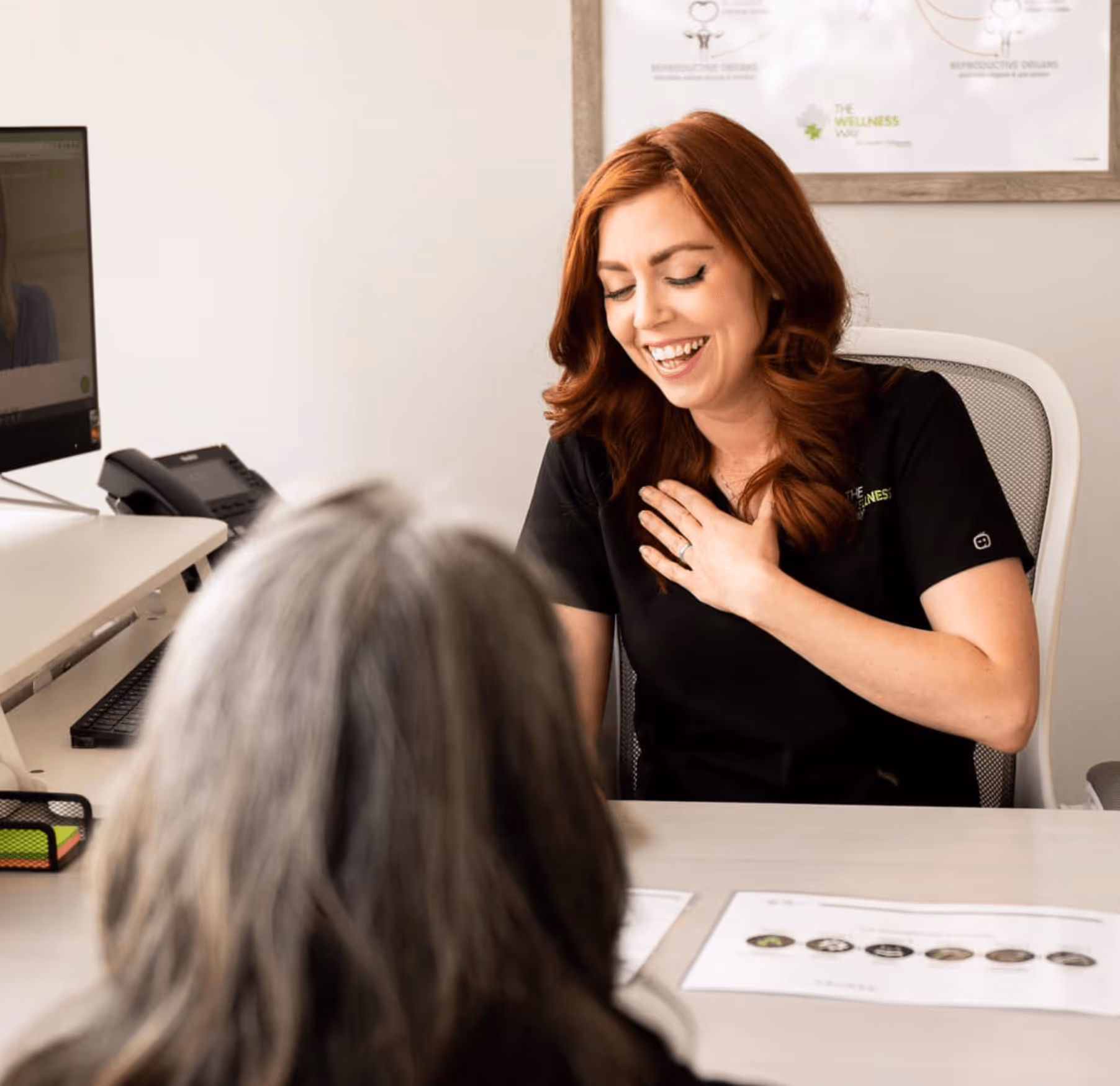 A healthcare professional from The Wellness Way smiling warmly during a consultation with a patient