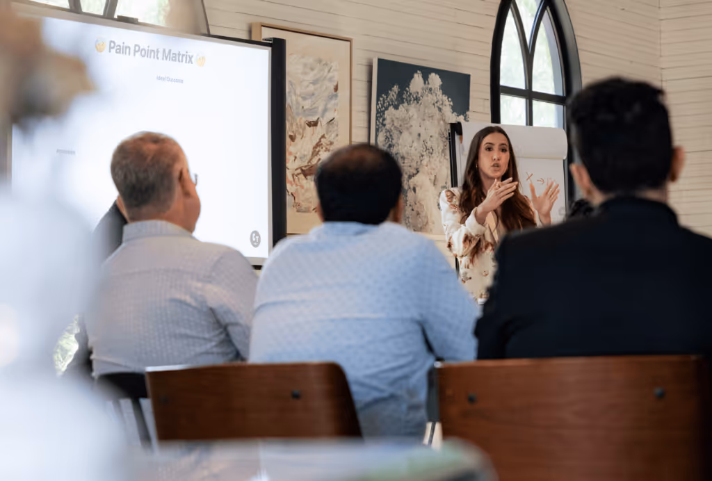 Codie Sanchez leading a workshop session explaining the Pain Point Matrix to attendees.