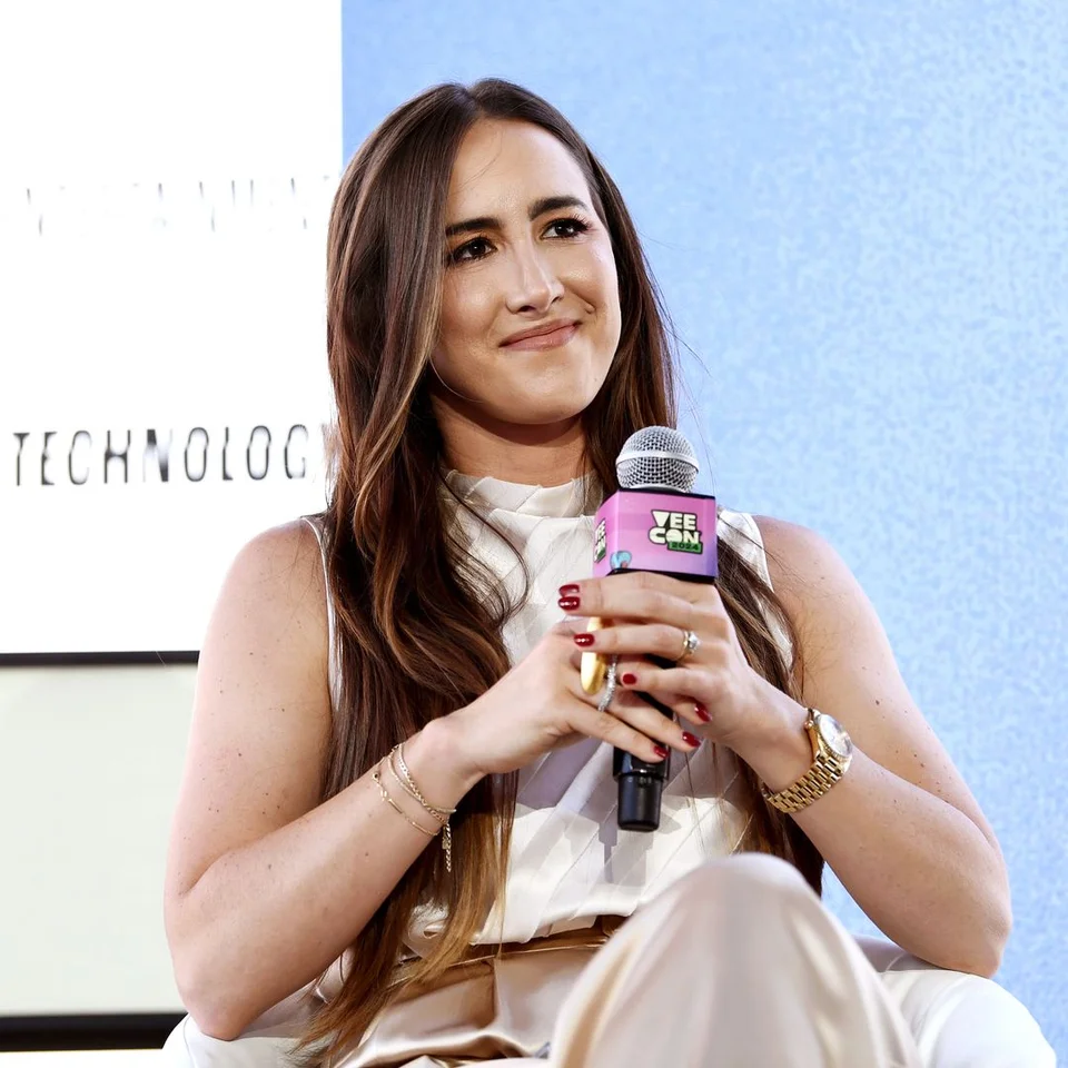 Codie Sanchez sitting on stage with a microphone