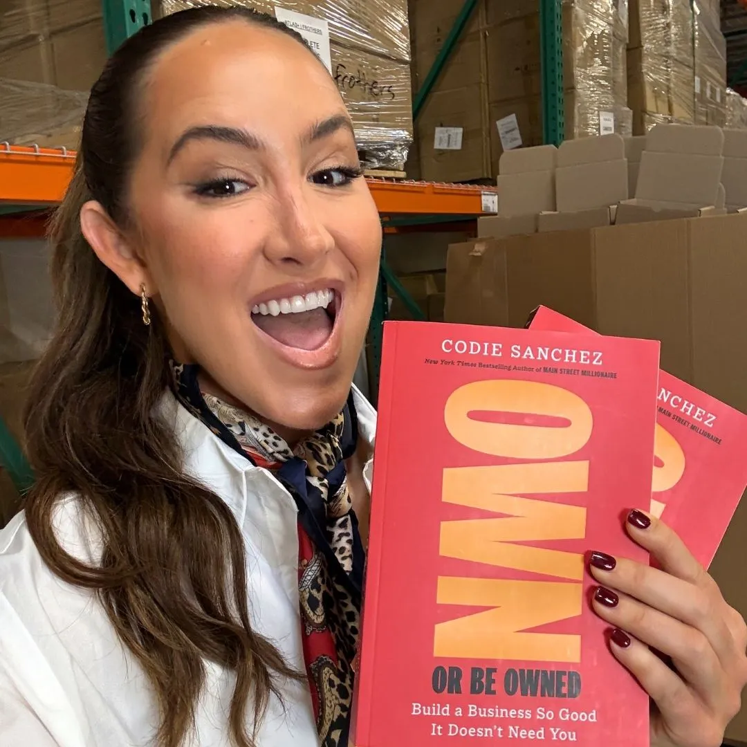 Codie Sanchez holding her book Own and Be Owned 