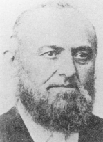 Black and white portrait of a man with a full beard and mustache looking slightly to his left.