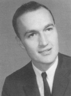 Black and white portrait of a young man in a suit and tie looking slightly to the side.