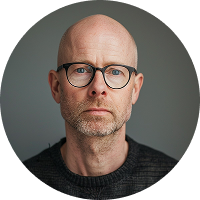 Portrait of a bold middle-aged man wearing glasses.